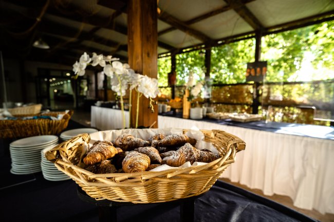 Cestino di croissant su un tavolo in una sala luminosa.