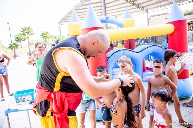 Animatore intrattiene bambini davanti a un gonfiabile.