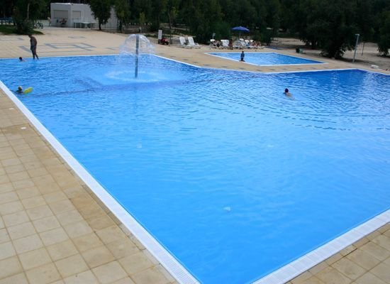 Piscina all'aperto con fontana al centro.