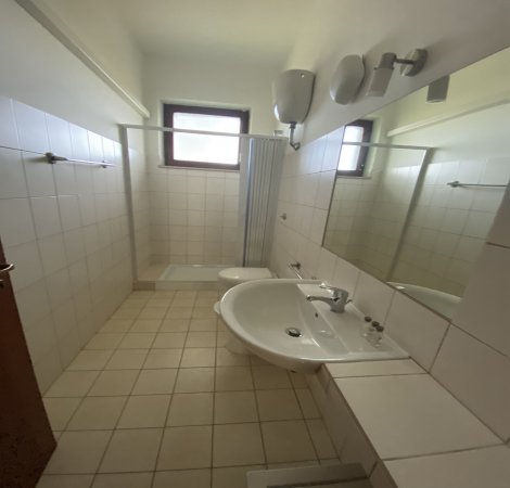 Bagno con specchio sopra un lavandino.