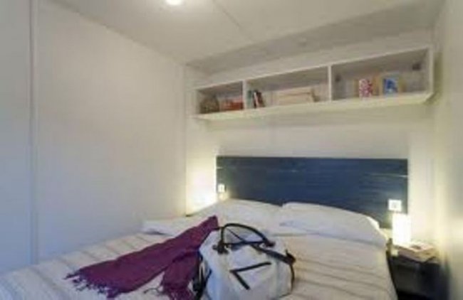 Camera da letto con decorazioni semplici e mensola.