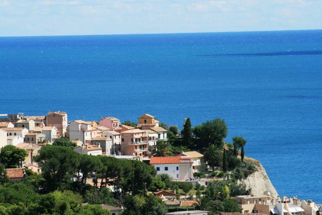Vista panoramica su un villaggio costiero con mare blu.