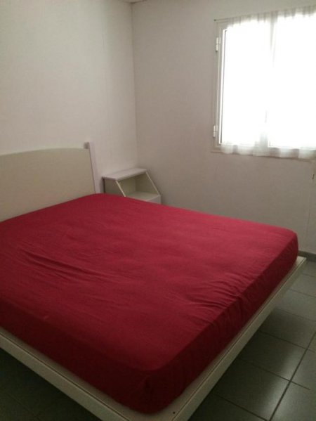 Stanza con letto matrimoniale e lenzuolo rosso.