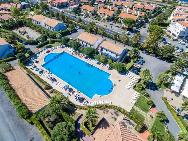 Vista aerea di un ampio complesso con piscina, circondato da edifici e verde.