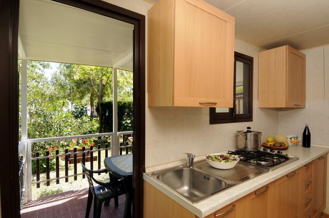 Cucina aperta su terrazza verde.