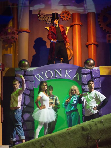 Sei persone in scena davanti a un'insegna Wonka.