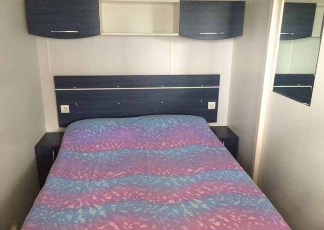 Camera da letto con letto matrimoniale e armadietti blu.