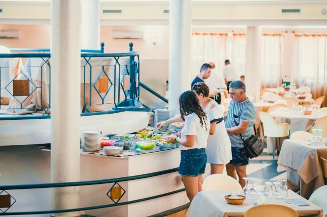Persone che scelgono cibo da un buffet.