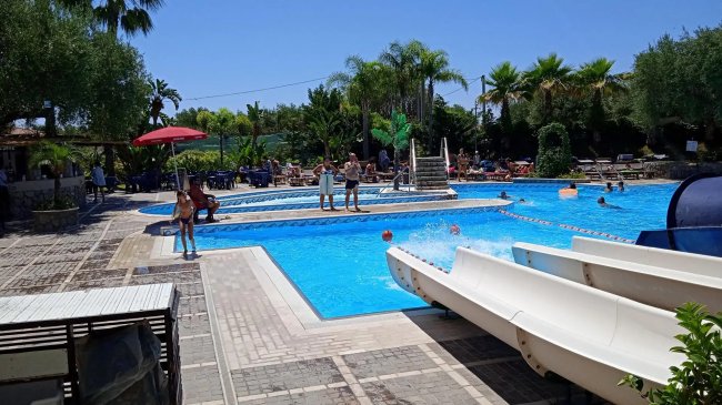 Scivoli in una piscina all'aperto con persone.